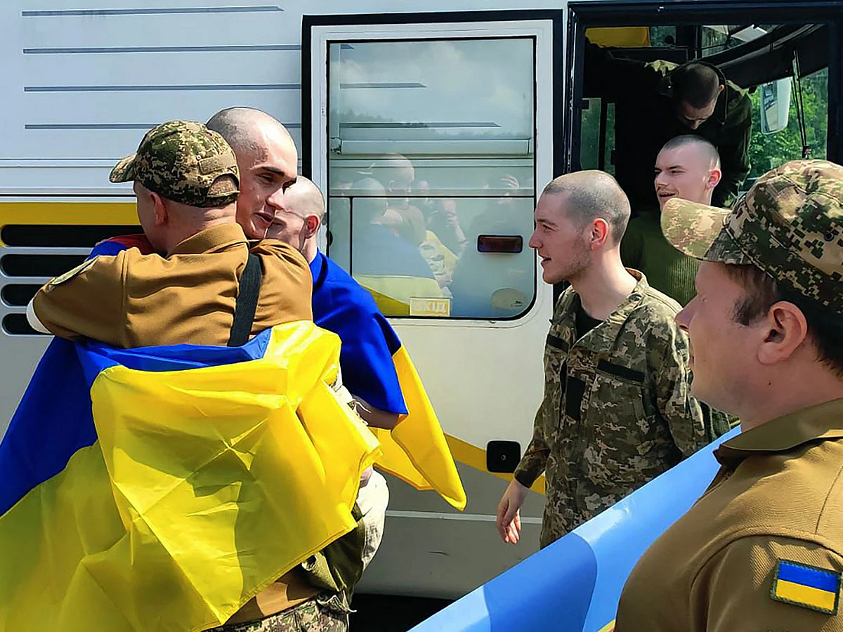 Ukrainian prisoners of war (POWs) wrapped with Ukrainian national flags react following an exchange at an undisclosed location, amid the Russian war in Ukraine. Russia said on June 9, 2025 it returned a group of prisoners -- all aged under 25 -- from Ukraine in the first stage of a major exchange of captives between Moscow and Kyiv that was agreed at Istanbul talks.  