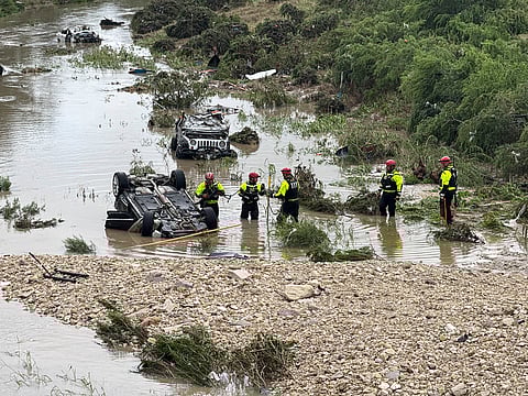 Authorities respond after vehicles were swept away by floodwaters in San Antonio, Texas, on Thursday, June 12, 2025. 