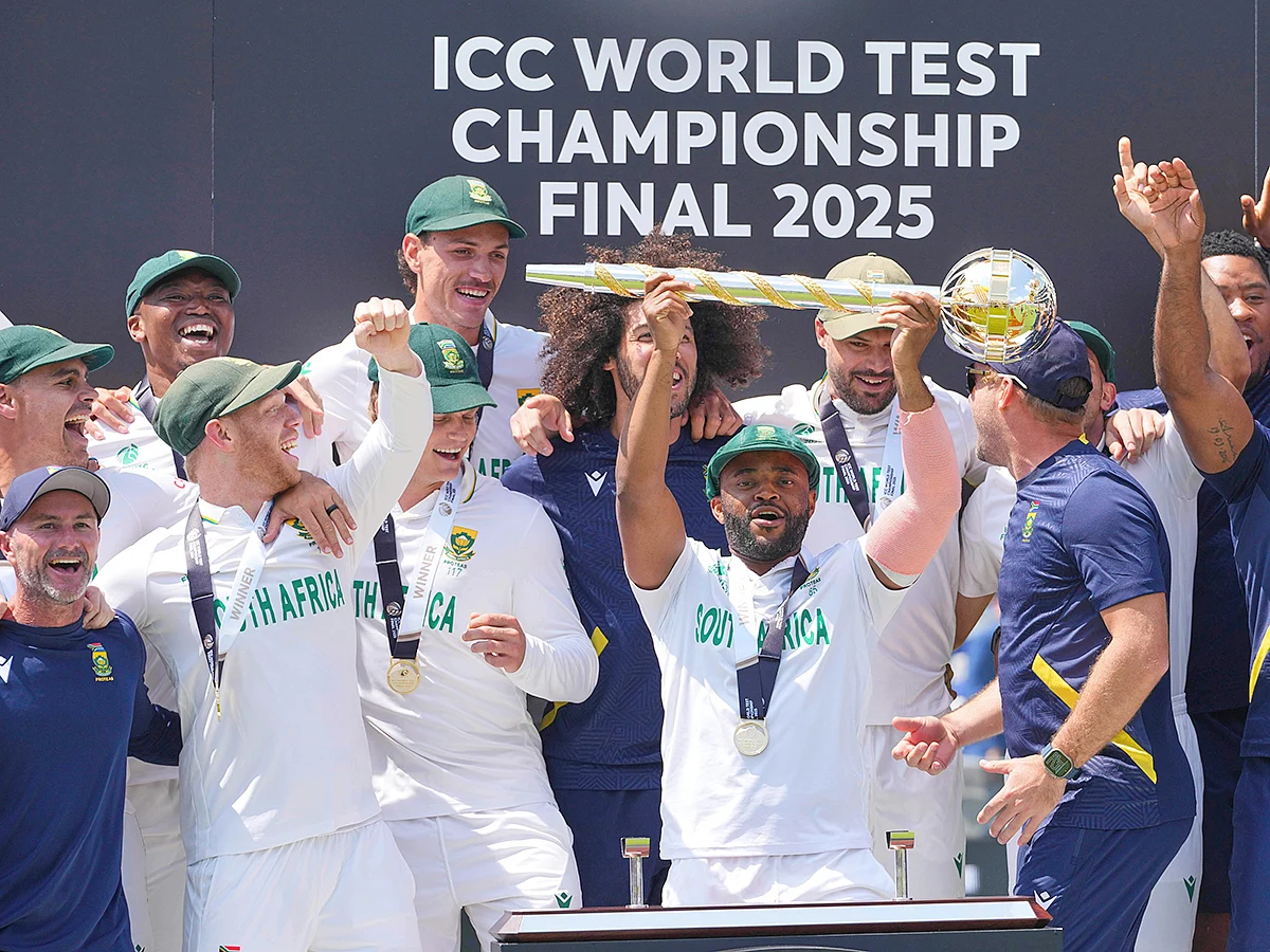 South Africa's captain Temba Bavuma holds the winner's trophy and celebrates with teammates after winning the World Test Championship, beating Australia at Lord's cricket ground in London, on June 14, 2025. 