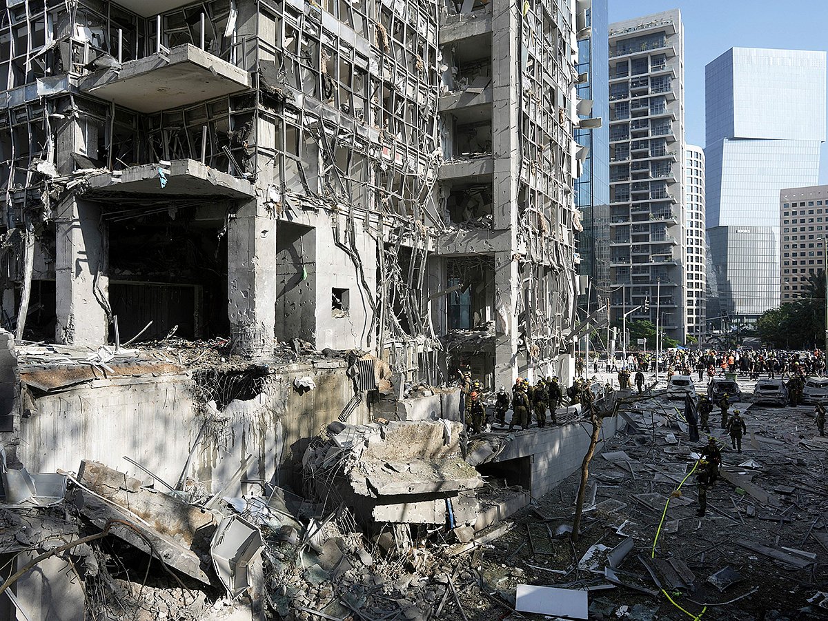 Rescue workers and military personnel inspect the site of a direct hit from an Iranian missile strike in Ramat Gan, Israel, Thursday, June 19, 2025. 