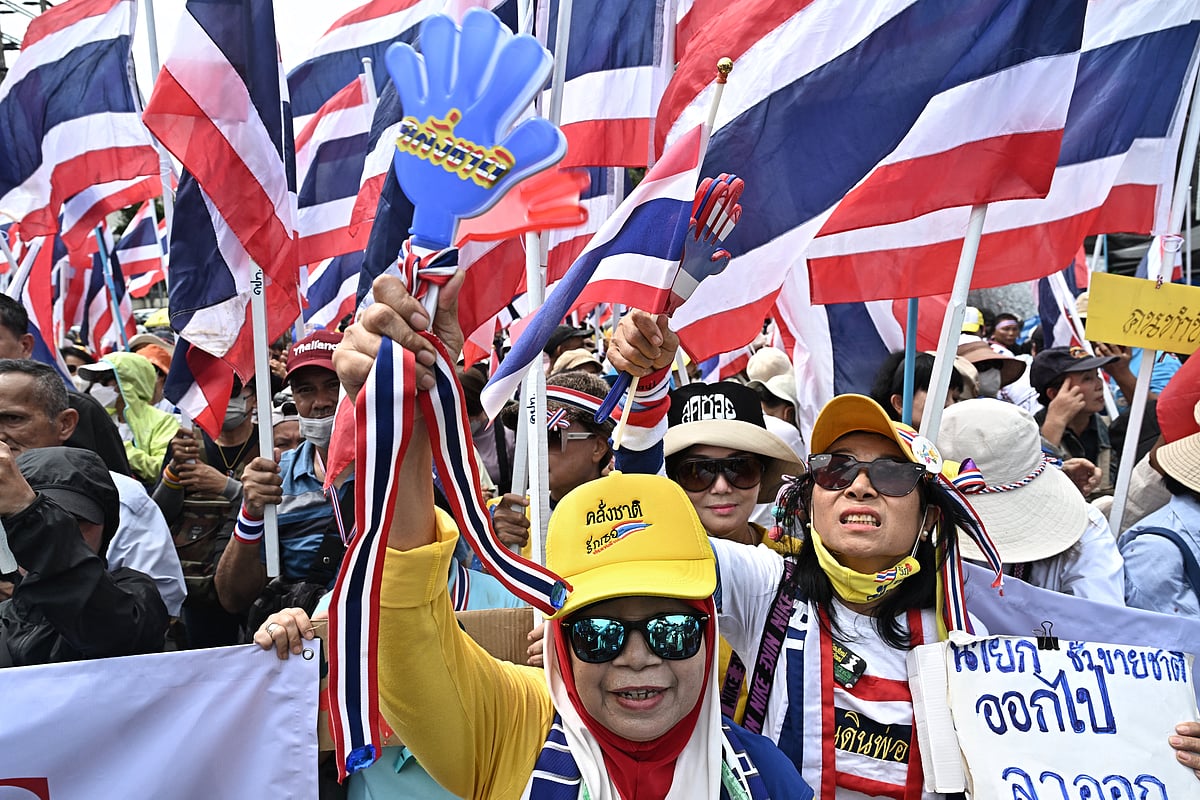 Anti-government protesters hold Thai national flags during a demonstration to demand the removal of Thailand's Prime Minister Paetongtarn Shinawatra from office outside Government House in Bangkok on June 19, 2025.
