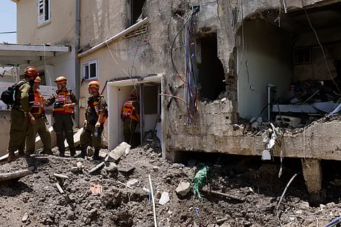 Israeli soldiers and first responders check the damage caused to a building from an Iranian strike in Beit She'an on June 21, 2025, amid the ongoing fire exchange between Iran and Israel.