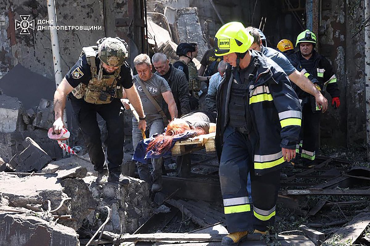 This photo taken and handout on June 24, 2025 by the State Emergency Service of Ukraine shows first responders evacuating a wounded person from the rubble of a building following a Russian missile strike in the eastern Ukrainian city of Dnipro.