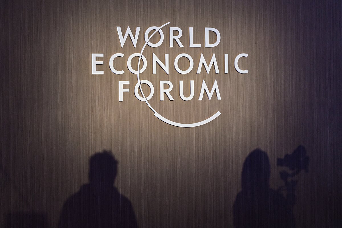 Shadows of journalists are seen beside WEF signage during a session at the World Economic Forum Annual Meeting of the New Champions 2025 (AMNC25) in Tianjin on June 24, 2025.