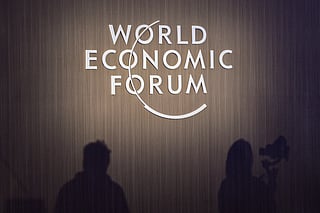 Shadows of journalists are seen beside WEF signage during a session at the World Economic Forum Annual Meeting of the New Champions 2025 (AMNC25) in Tianjin on June 24, 2025.