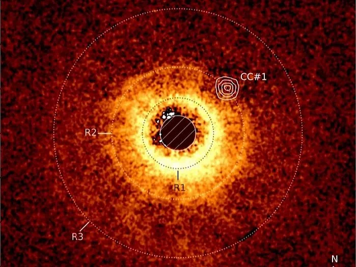 Image of the disk around the star TWA 7 recorded using ESO's Very Large Telescope's SPHERE instrument. The image captured with JWST’s MIRI instrument is overlayed. We can clearly see the empty area around TWA 7 B in the R2 ring (CC #1).