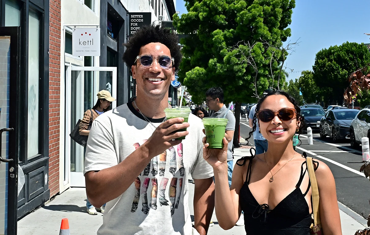Rohan Cutlip (L) and Alexis Underwood display their iced matcha lattes from Kettl Tea in the Los Feliz neighborhood of Los Angeles, California on May 20, 2025.
