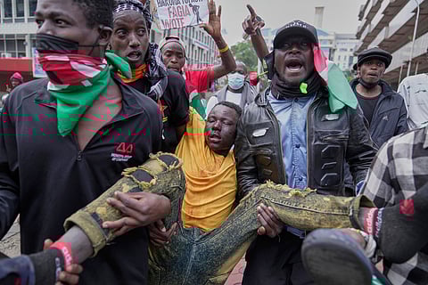 A man is carried by protesters after being beaten by anti riot police during a demonstration in downtown Nairobi, Kenya, Wednesday, June 25, 2025. 