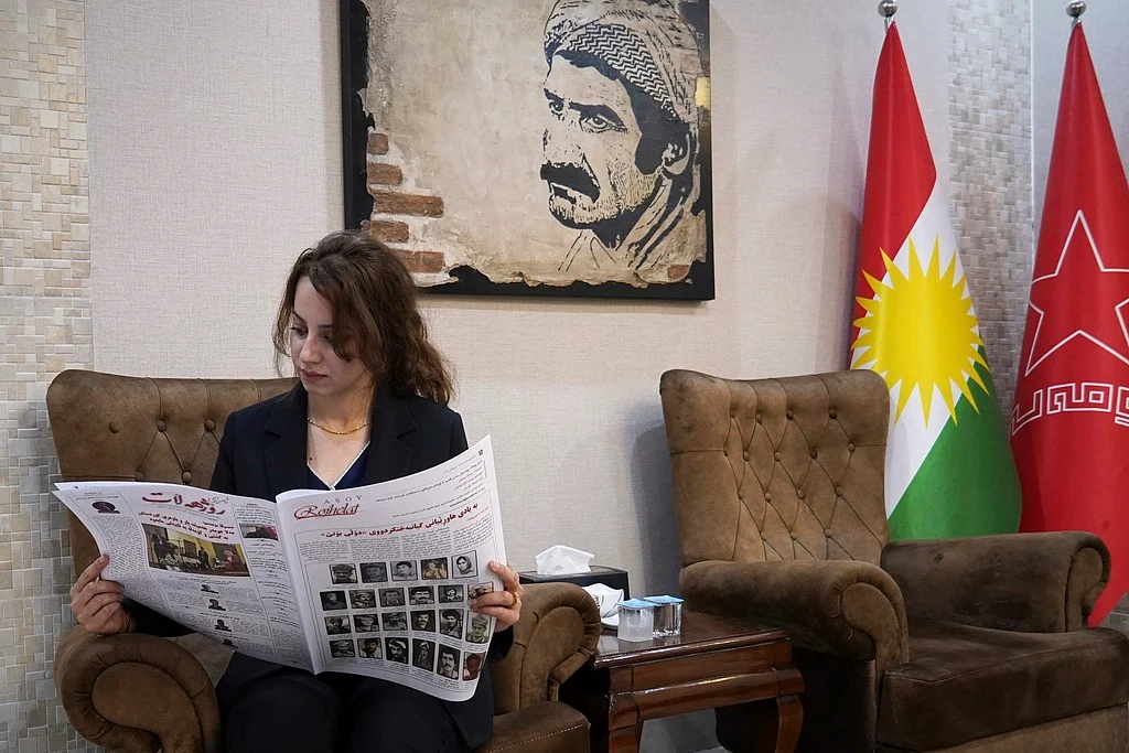 Kawsar Fattahi, a member of the central committee of the Komala Party of Iranian Kurdistan, reads the party's newspaper, Asoy Rojhelat, at one of its offices in an undisclosed location in Iraq's Irbil governorate, June 19, 2025. (AP Photo/Rashid Yahya)