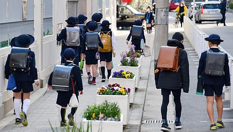 Young students make their way to school in Osaka, western Japan. In Japan, children in primary and junior high typically range in age from 6 to 15 years old. 