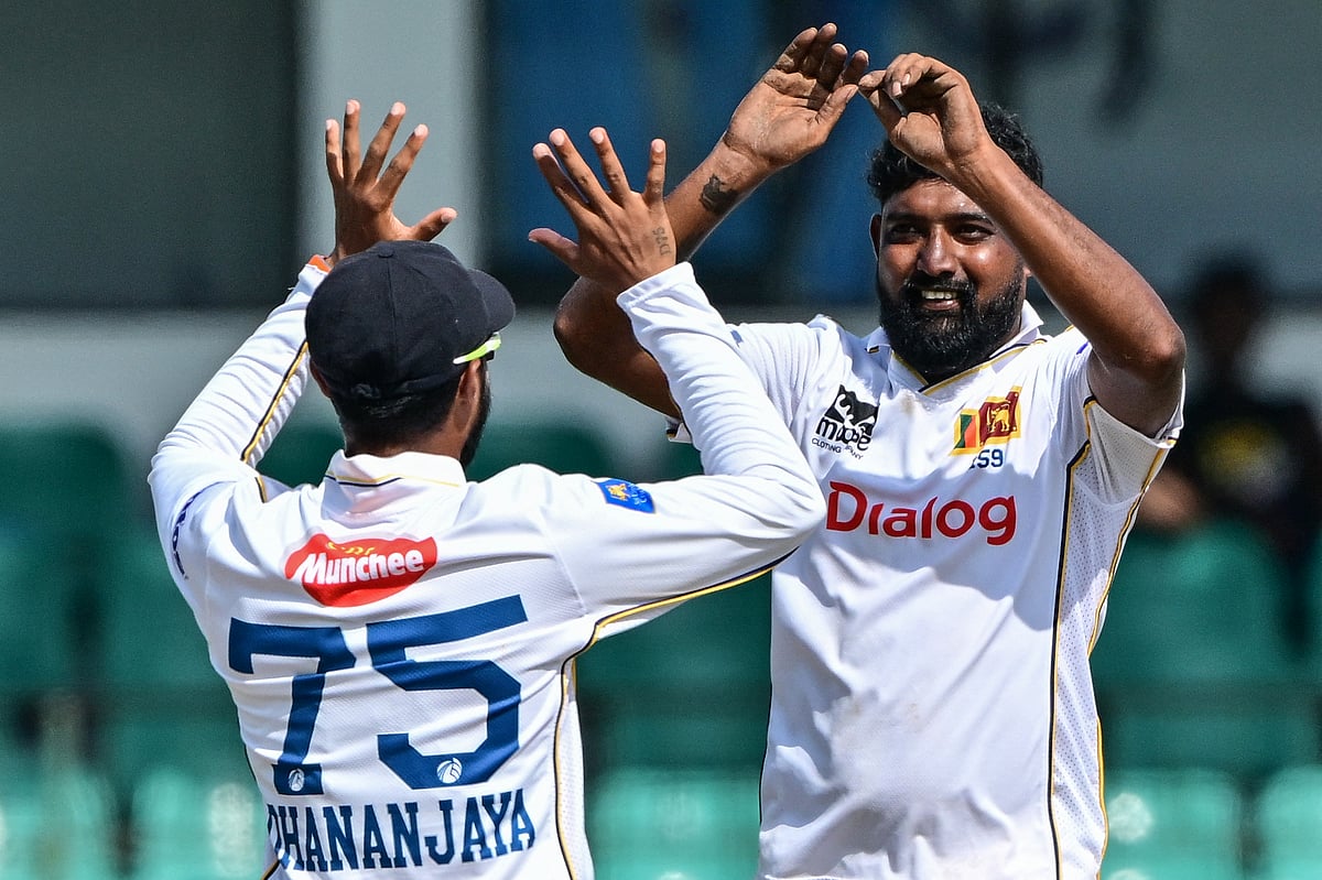 Sri Lanka's Prabath Jayasuriya (right) celebrates with his captain Dhananjaya de Silva after taking the wicket of Bangladesh's Shadman Islam during the third day of the second Test cricket in Colombo on June 27, 2025.