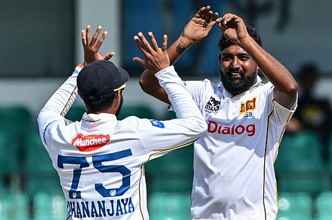 Sri Lanka's Prabath Jayasuriya (right) celebrates with his captain Dhananjaya de Silva after taking the wicket of Bangladesh's Shadman Islam during the third day of the second Test cricket in Colombo on June 27, 2025.