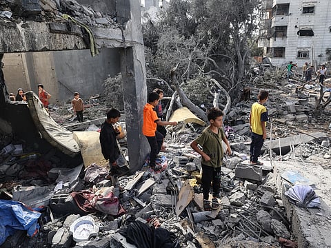 Palestinian children check the rubble of a residential house in Deir el-Balah in the central Gaza Strip on July 1, 2025, following overnight Israeli strikes as the war between the Palestinian Hamas militant and Israel continues.