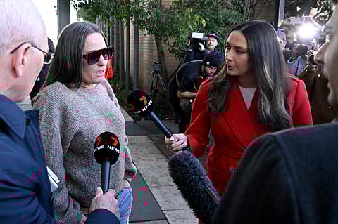 Members of the media talk to a friend of Erin Patterson as she leaves the Latrobe Valley Magistrates' Court in Morwell, where Patterson was found by a jury on July 7, 2025 to have murdered her husband's parents and aunt by lacing their beef Wellington lunch with toxic mushrooms at the climax of a trial watched around the world.