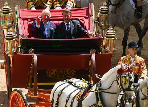 Britain's King Charles III and France's President Emmanuel Macron travel in the 1902 State Landau carriage during a carriage precession at Windsor Castle, in Windsor west of London, on July 8, 2025, on the first day of a three-day state visit to Britain.