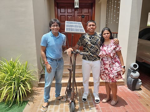 Param Bhimani (centre) with his parents and the solar-powered scooter he built.