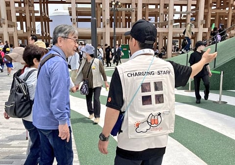 Harnessing the sun in style: On-site guides at Osaka Expo 2025 debut futuristic vests fitted with ultra-light perovskite solar cells—powering neck fans as they brave the summer heat.