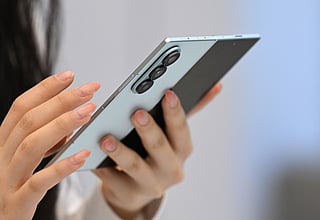 A visitor examines the Samsung Galaxy Z Fold7 smartphone at a Samsung store in Seoul on July 10, 2025.