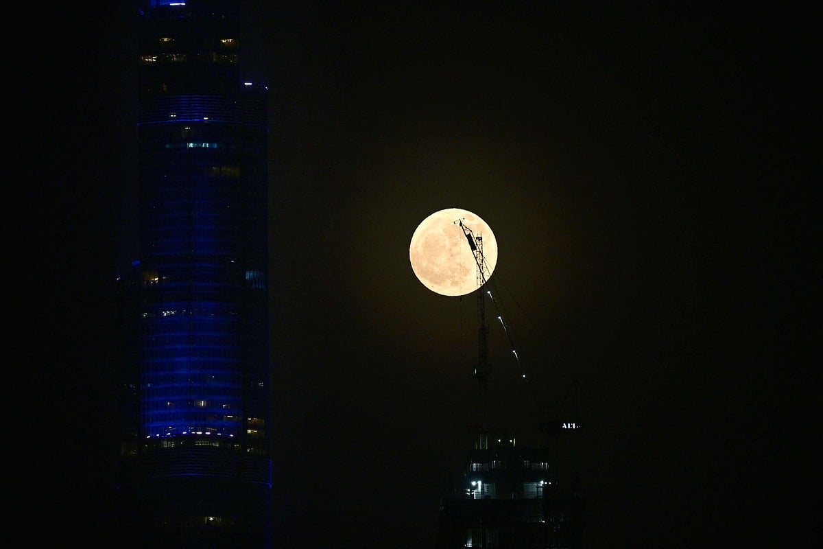 The moon rises behind Burj Khalifa, the world’s tallest building, in Dubai on July 10, 2025. 