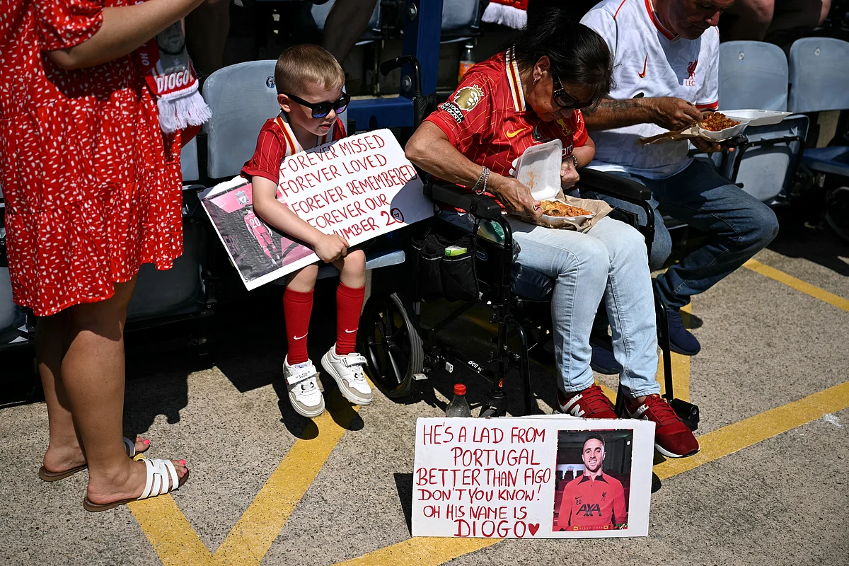 Fans hold signs in memory of Liverpool's late Portuguese striker #20 Diogo Jota before the pre-season friendly football match between Preston North End and Liverpool at Deepdale stadium in Preston, north-west England on July 13, 2025.