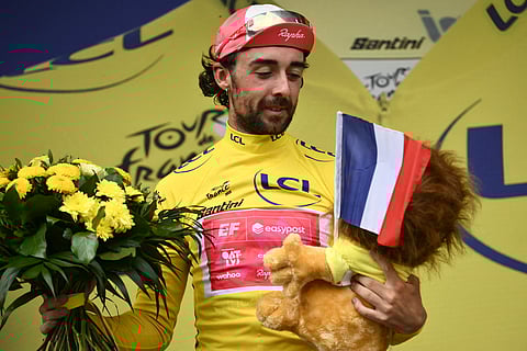 EF Education - EasyPost team's Irish rider Ben Healy celebrates on the podium with the overall leader's yellow jersey after the 10th stage of the 112th edition of the Tour de France cycling race, 165.3 km between Ennezat and Le Mont-Dore Puy de Sancy, in central France, on July 14, 2025.