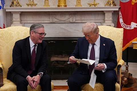 British Prime Minister Keir Starmer, left, hands an invitation from King Charles III for a second state visit to President Donald Trump at the White House, Thursday, Feb. 27, 2025, in Washington. 