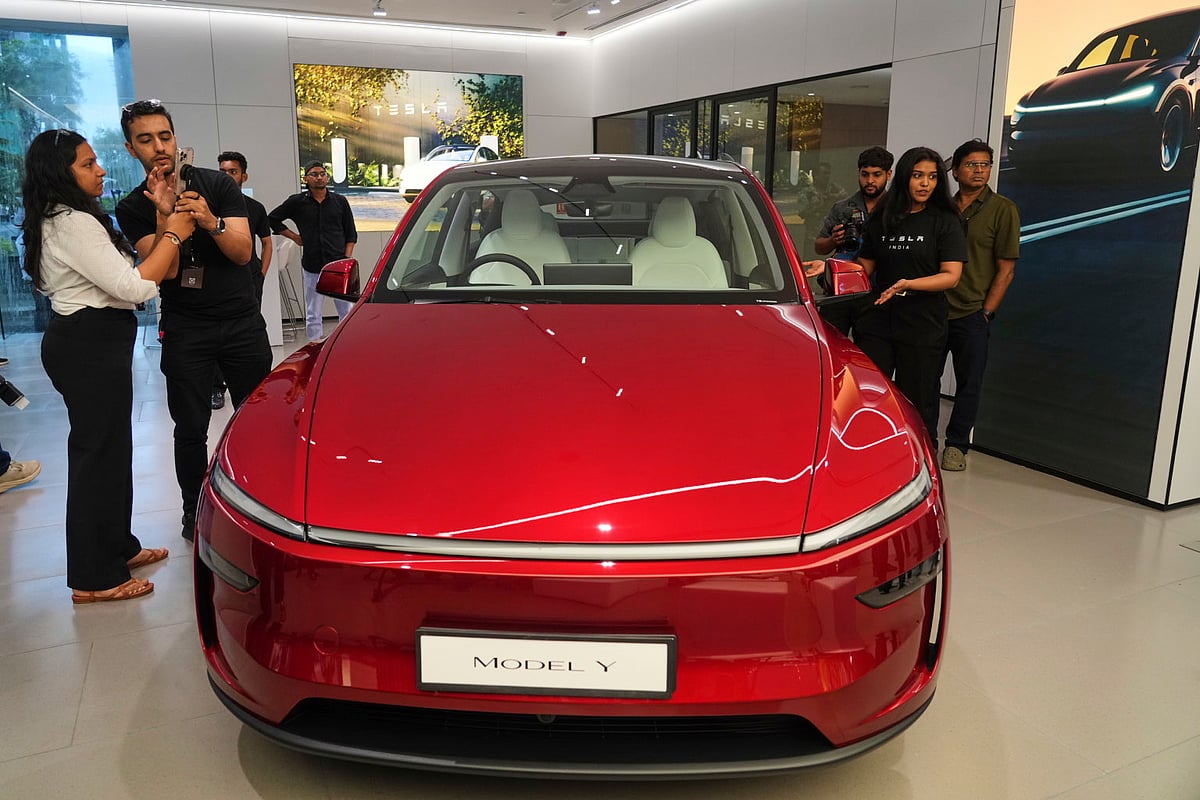 Media personnel gather near the Tesla's 'Model Y' vehicle during the inauguration of India's first Tesla showroom, in Mumbai on July 15, 2025.