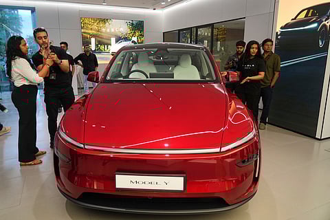 Media personnel gather near the Tesla's 'Model Y' vehicle during the inauguration of India's first Tesla showroom, in Mumbai on July 15, 2025.