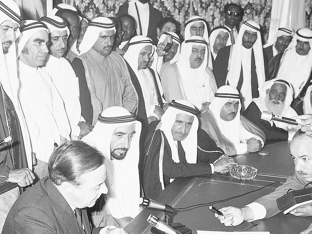 Shaikh Zayed Bin Sultan Al Nahyan - in the presence of Shaikh Rashid Bin Saeed Al Maktoum, the then Ruler of Dubai, Shaikh Khalid Bin Mohammad Al Qasimi, the then Ruler of Sharjah, Shaikh Rashid Bin Humaid Al Nuaimi, the then Ruler of Ajman, Shaikh Mohammad Bin Ahmad Al Sharqi, the then Ruler of Fujairah, and other dignitaries and officials - listens to British diplomat Sir Geoffrey Arthur as he reads out the contents of the document during the proclamation of the Union and the declaration of independence in 1971. - WAM