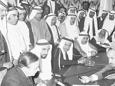 Sheikh Zayed bin Sultan Al Nahyan, in the presence of Sheikh Rashid bin Saeed Al Maktoum, the then ruler of Dubai, Sheikh Khalid bin Mohammad Al Qasimi, the then ruler of Sharjah, Sheikh Rashid bin Humaid Al Nuaimi, the then ruler of Ajman, Sheikh Mohammad bin Ahmad Al Sharqi, the then ruler of Fujairah, and other dignitaries and officials - listens to British diplomat Sir Geoffrey Arthur as he reads out the contents of the document during the proclamation of the Union and the declaration of independence in 1971.