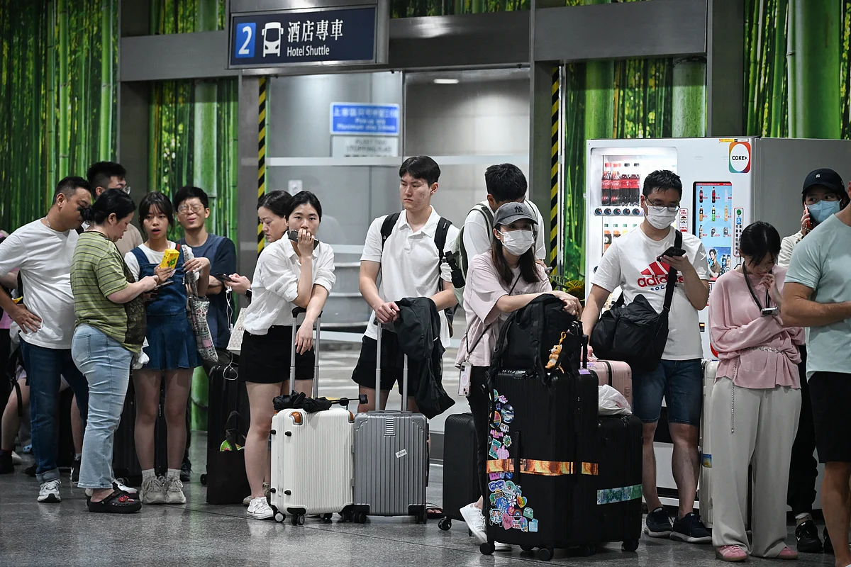 Outbound travellers wait for the Airport Express train to resume service to the Hong Kong international airport, as Typhoon Wipha moves away from the city on July 20, 2025. Acording to RTHK, about 80,000 passengers were affected in Hong Kong alone. 