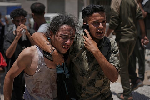 Palestinians react after carrying the bodies of those killed while trying to reach aid trucks entering northern Gaza.