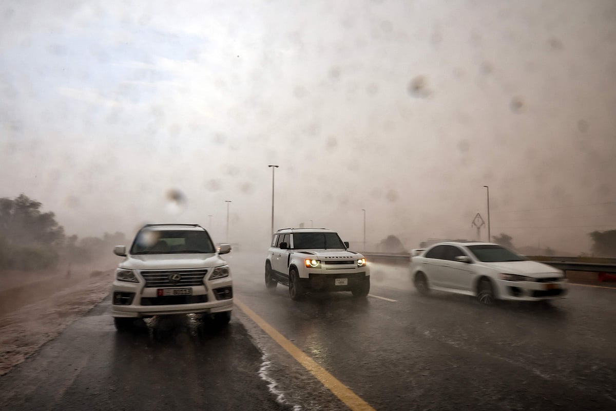Rain pours over Al Ain Road, as drivers move cautiously through the downpour.