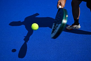 A padel tennis player is silhouetted at the Beziers Indoor Padel club in Beziers, southern France on July 22, 2025.