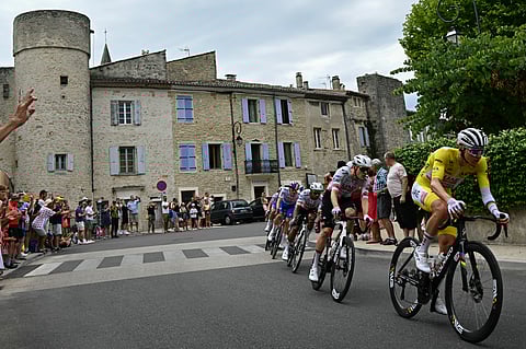 UAE Team Emirates - XRG team's Slovenian rider Tadej Pogacar wearing the overall leader's yellow jersey cycles with the pack of riders (peloton) during the 17th stage of the 112th edition of the Tour de France cycling race, 160.4 km between Bollene and Valence, southern France, on July 23, 2025.