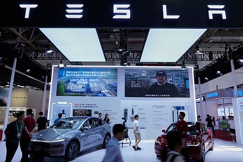 People visit a booth of Tesla during the 3rd China International Supply Chain Expo at the China International Exhibition Center, in Beijing, China, Friday, July 18, 2025. (AP Photo/Mahesh Kumar A.)