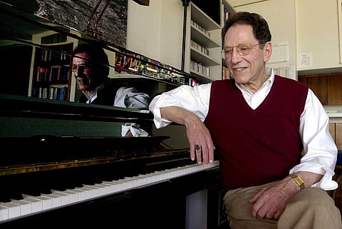 FILE - Musician Tom Lehrer sits beside the piano in his house in Santa Cruz, Calif., on April 21, 2000. (AP Photo/Paul Sakuma, File)