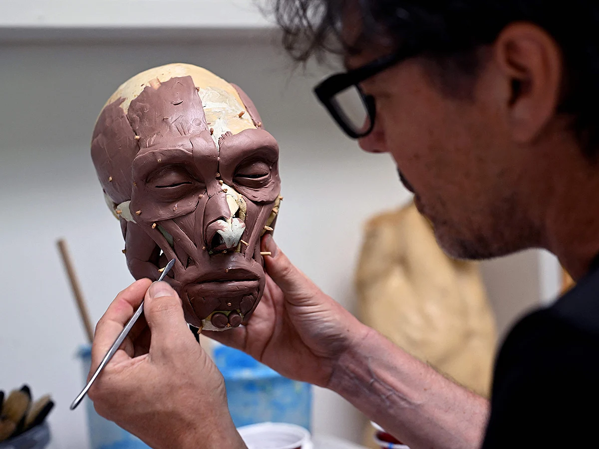 Dutch artist Alfons Kennis works on a model representing a prehistoric human skull in his workshop in Arnhem, on July 3, 2025. 