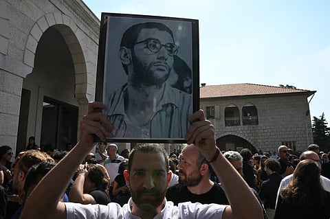 A man carries a portrait of renowned musician and composer Ziad Rahbani, during the funeral ceremony at Mhaidseh's Greek Orthodox Church of Dormition in Bikfaya in Mount Lebanon, north east of Beirut, on July 28, 2025.
