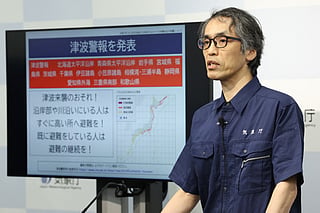 An expert on earthquake and tsunami countermeasures from the Japan Meteorological Agency holds a press conference in Tokyo on July 30, 2025, following a 8.7 magnitude quake in the sea off eastern Russia.