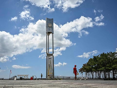 A lifeguard (R) patrols the area along the coast as much of coastal Japan went on alert following a 8.8 magnitude quake in the sea off eastern Russia, along Tokyo Bay in Chiba City, Chiba prefecture on July 30, 2025. 