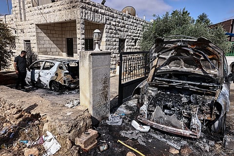 People inspect the damage after an Israeli settler attack at dawn that torched a house and nearby cars and led to the reported death of a Palestinian man by asphyxiation, in Silwad town northeast of Ramallah in the occupied West Bank on July 31, 2025.