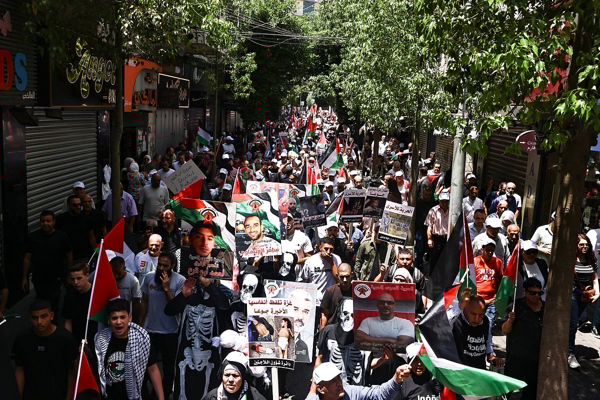 Demonstrators, some dressed in human skeleton costumes, carry bloodied bundles and raise pictures of Palestinian prisoners held in Israeli jails, during a protest in solidarity with the people of the Gaza Strip and Palestinian detainees, in the occupied-West Bank city of Ramallah on August 3, 2025.