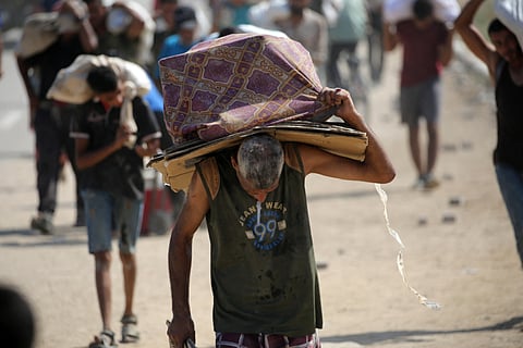 A Palestinian man carries folded cardboard boxes as he returns from a food distribution point run by the US and Israeli-backed Gaza Humanitarian Foundation (GHF) group, near the Netsarim corridor in the central Gaza Strip on August 3, 2025.