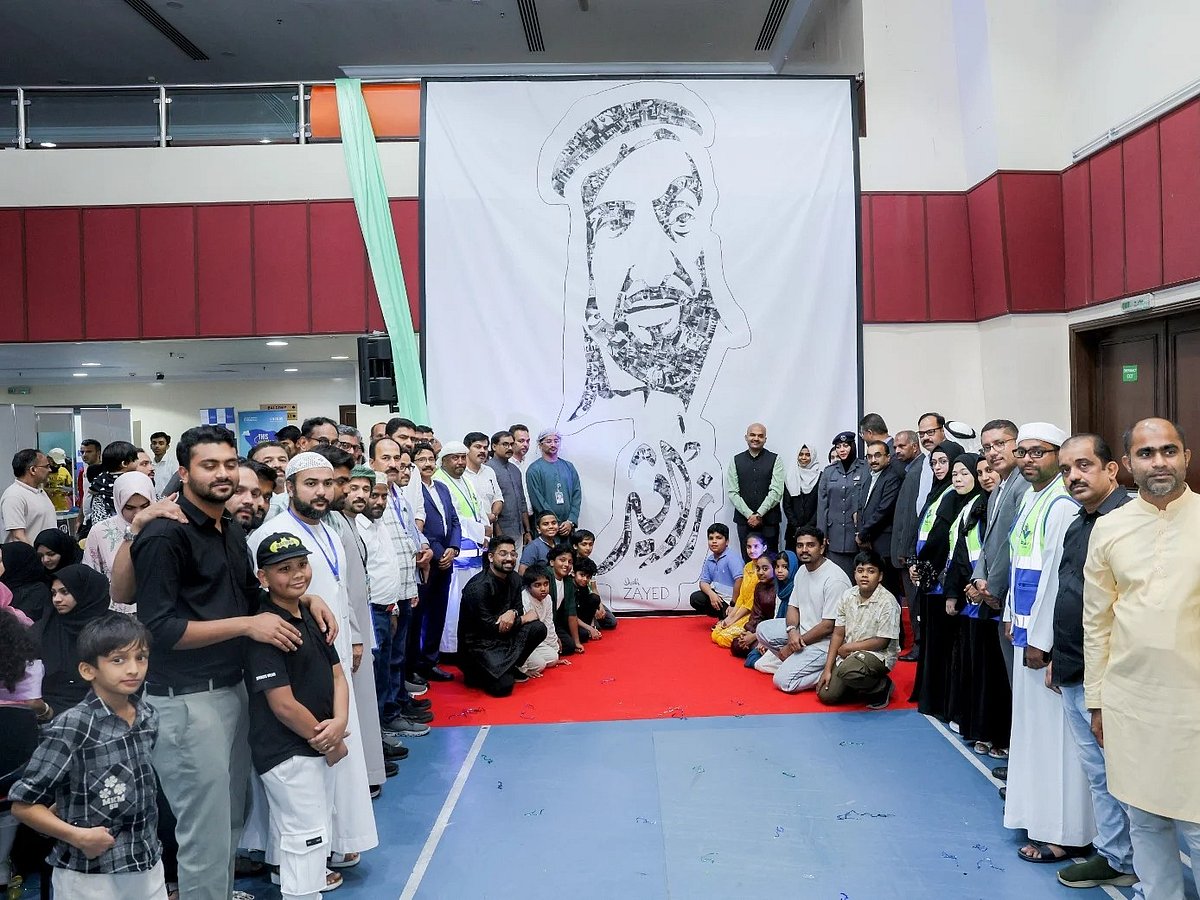 Students who created the collage pose for a photo with community members at the unveiling ceremony recently held in Abu Dhabi. 