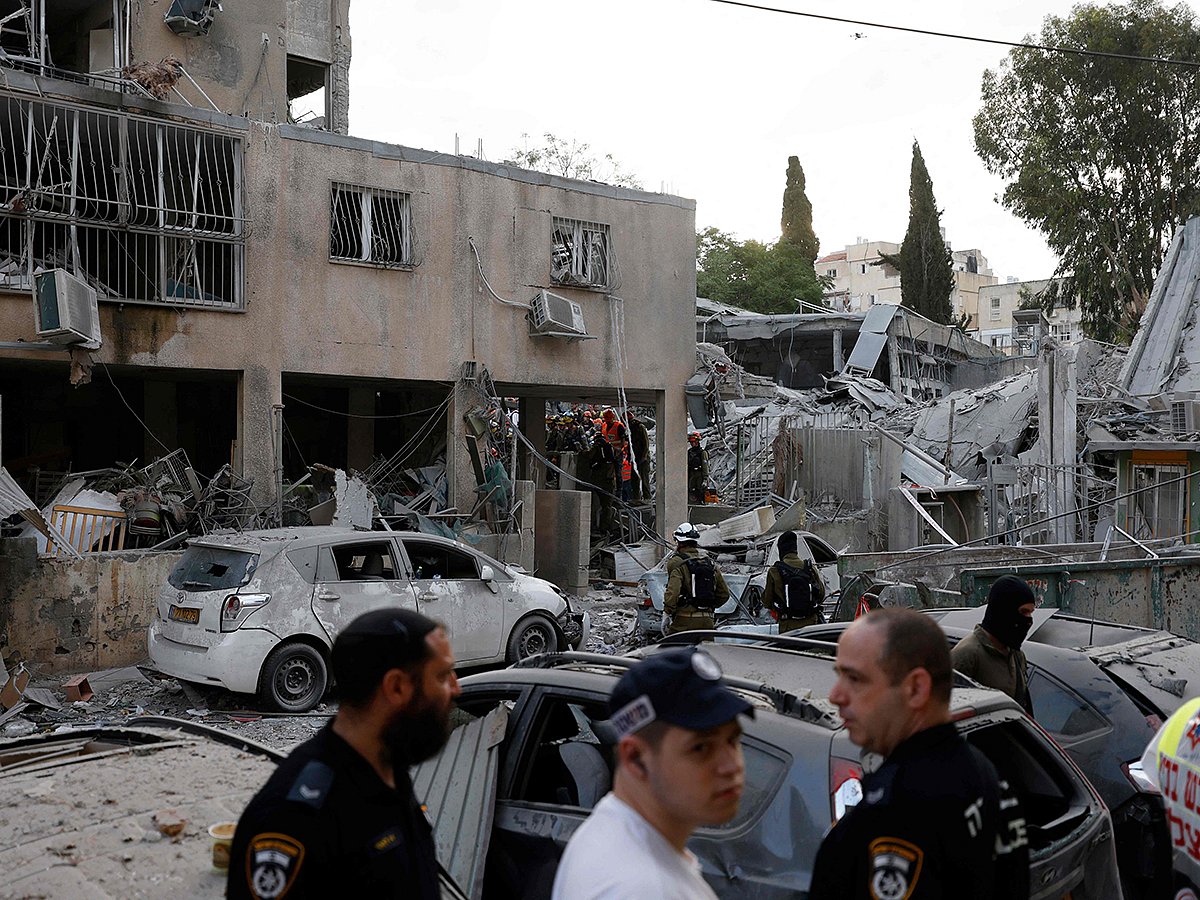 Rescuers work near a damaged building following a strike by an Iranian missile in the Israeli city of Bnei Brak, east of Tel Aviv, on June 16, 2025. 