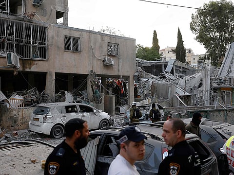 Rescuers work near a damaged building following a strike by an Iranian missile in the Israeli city of Bnei Brak, east of Tel Aviv, on June 16, 2025. 