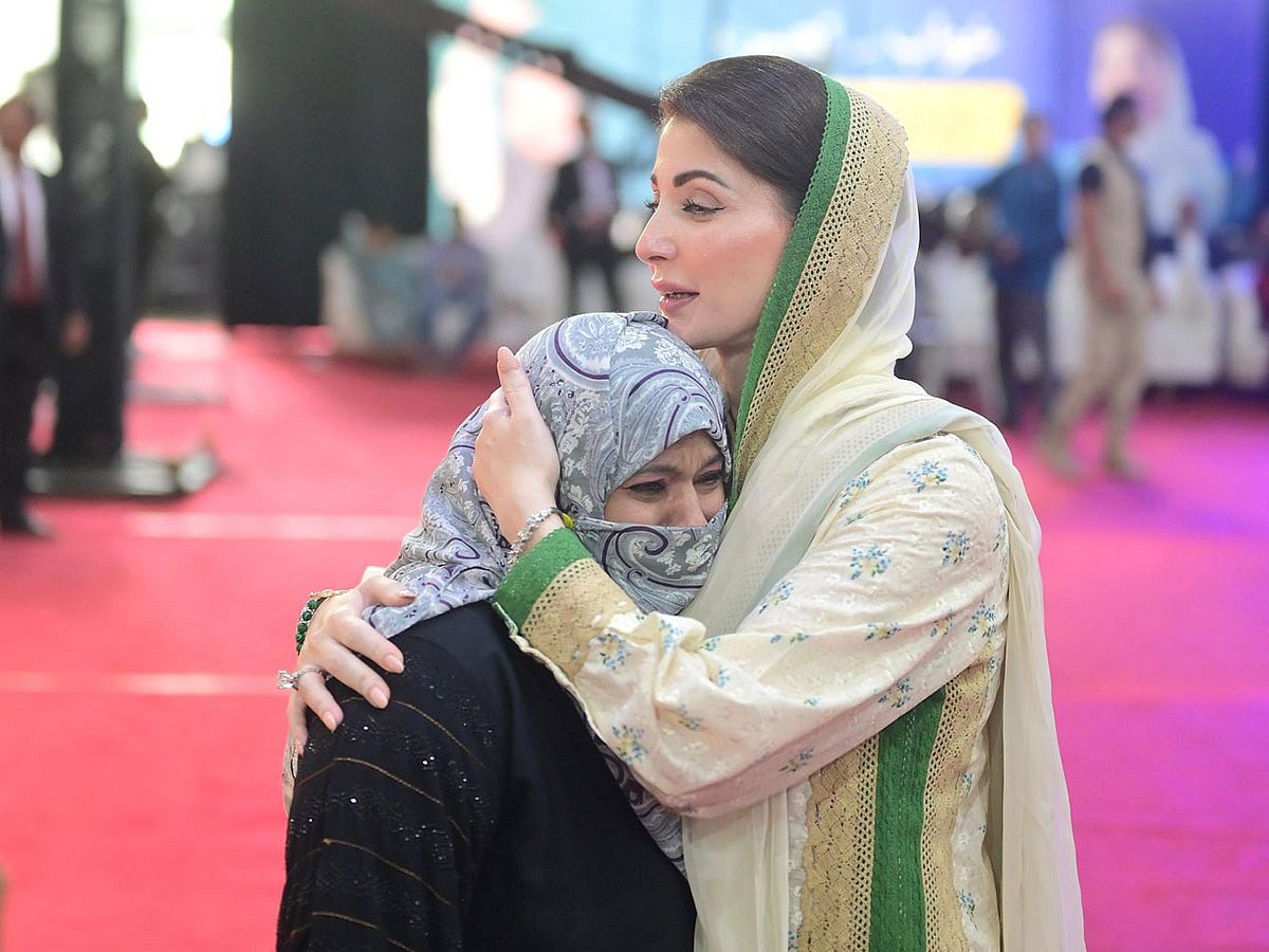 Punjab Chief Minister Maryam Nawaz comforting a family during home distribution ceremony in Lahore
