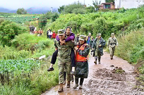 Rescue workers evacuate residents after a flash flood in Yuzhong county, in China’s northwest Gansu province on August 8, 2025.