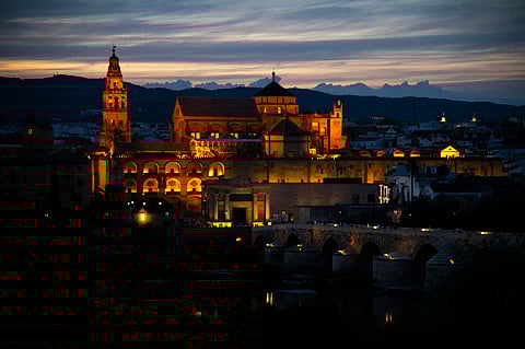The Mosque-Cathedral of Cordoba is pictured next to the Roman bridge on June 11, 2023.